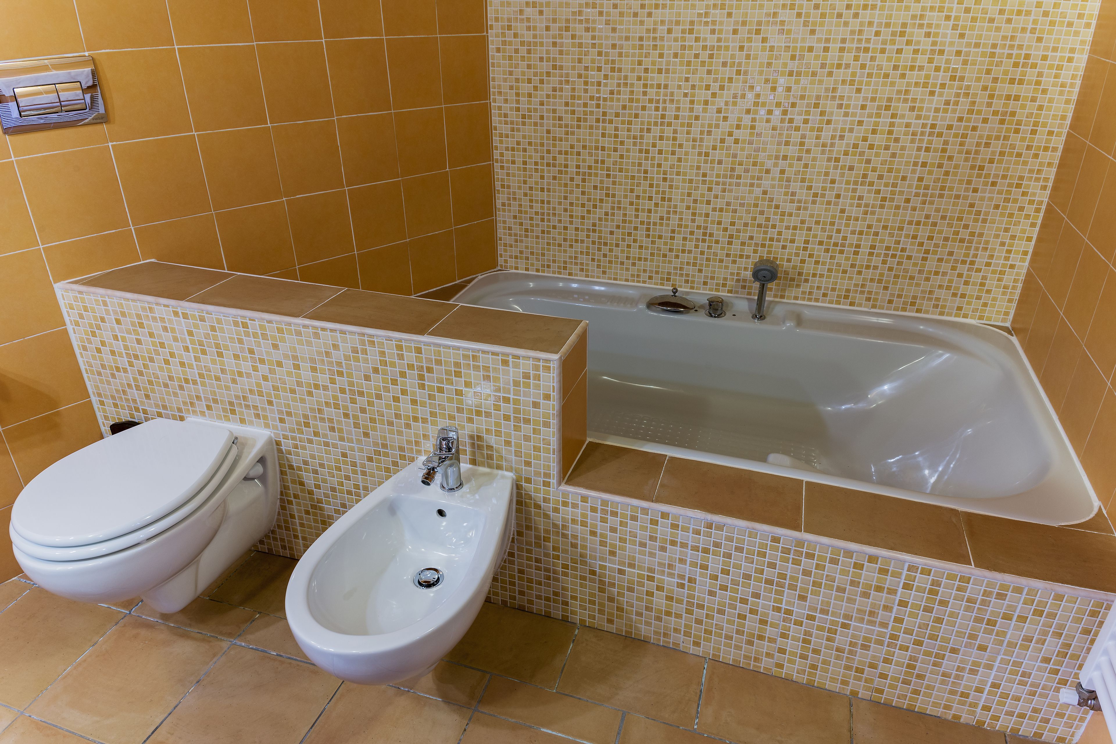 A bathroom with a toilet, bidet, and bathtub.