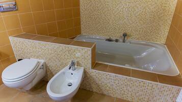 A bathroom with a toilet, bidet, and bathtub.
