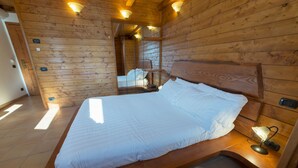 Una habitación con paneles de madera, una cama, una mesita de noche y un espejo.