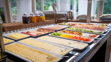 Ein reichhaltiges Buffet mit verschiedenen Speisen, darunter Fleisch, Käse und Gemüse.
