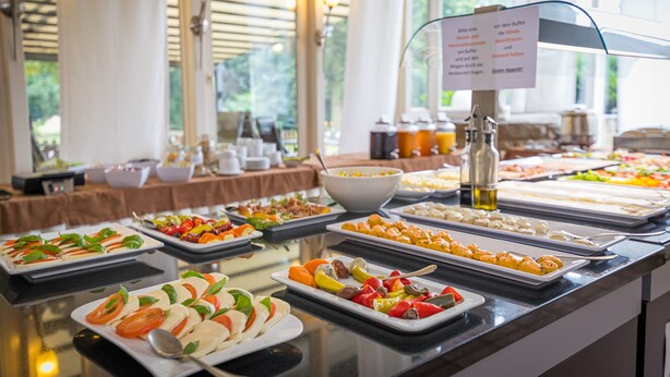 Un bufé con diversas opciones de comida y un cartel con el menú.