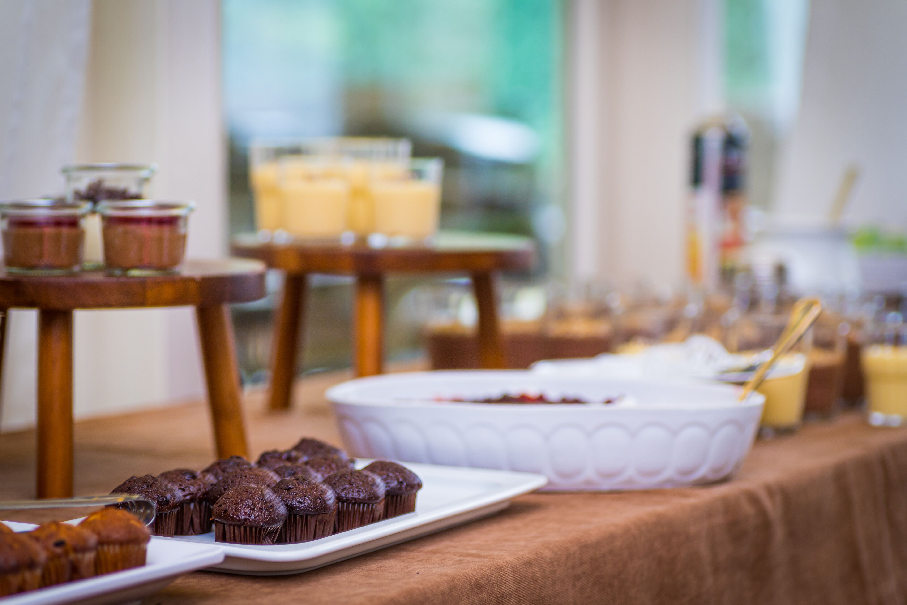 Una mesa de buffet con diversos alimentos, incluyendo muffins y postres.