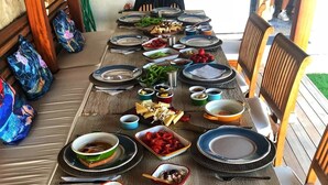 A dining table set with various dishes and condiments, surrounded by chairs. - LilaVerde Alacati - Adults Only (Cesme)