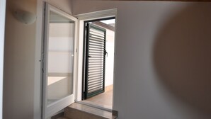 A wooden staircase leading to an open door with a view of a building outside. - Affittacamere Da Mary (Matera)