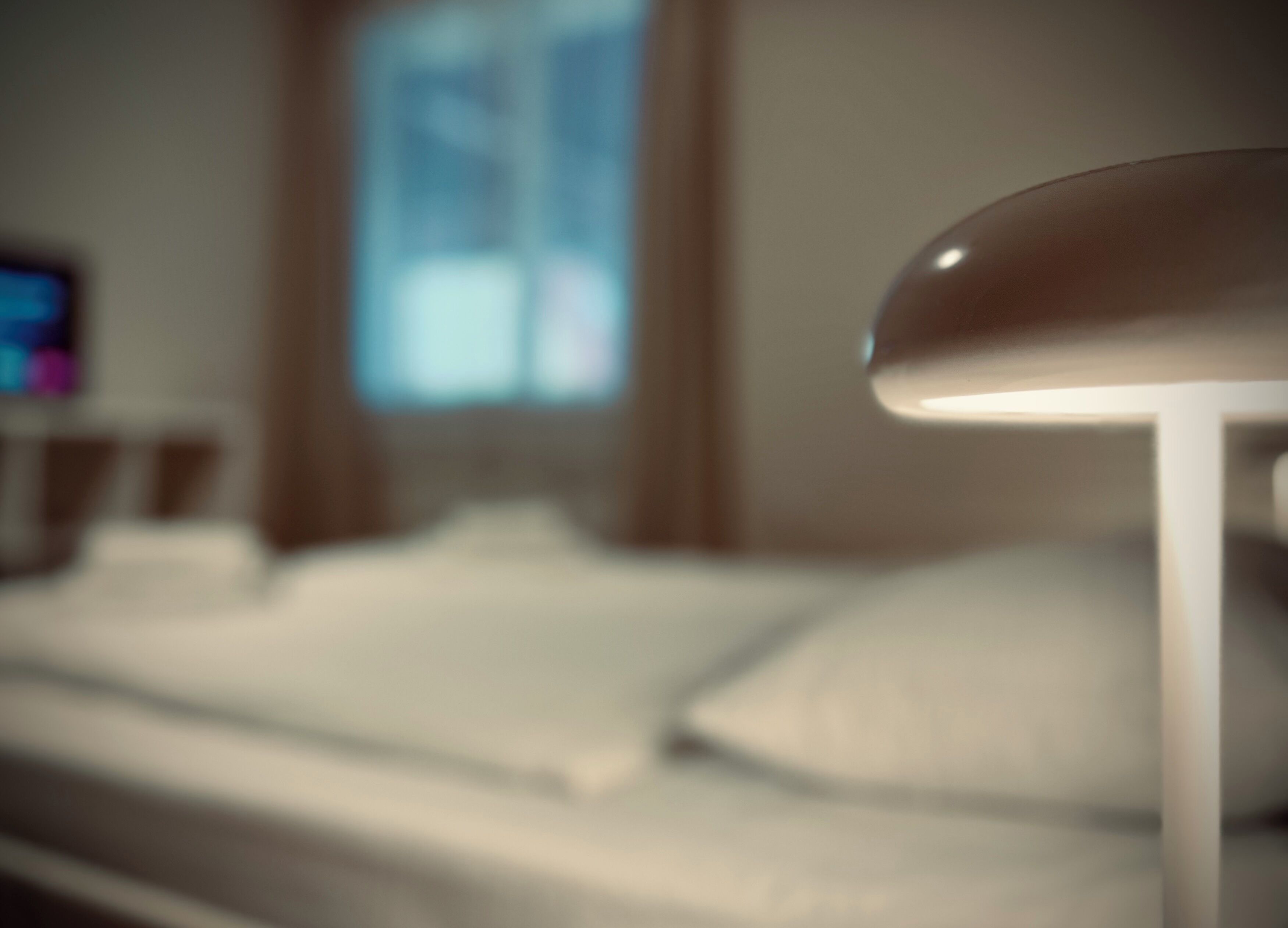 Una cama con sábanas blancas en una habitación de hotel.