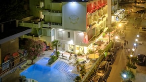 A hotel with a swimming pool, outdoor seating, and a street view. - Si Rimini Hotel (Rimini)