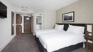A hotel room with a large bed, a flat-screen TV, a wardrobe, a bathroom, and a cityscape picture on the wall. - Spring River Ebbsfleet by Marston's Inns (Gravesend)