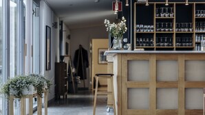 A modern bar area with a wooden counter, glassware, and a vase with flowers. - Fårösunds Fästning (Fårösund)