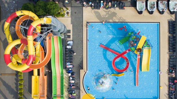 Vista aérea de un parque acuático con varias toboganes y una zona de natación.