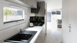 Una cocina moderna con un lavamanos empotrado, un hervidor y una estufa.