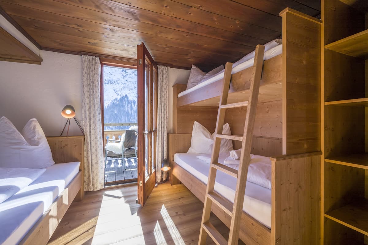 Una cabaña acogedora con literas de madera, una mesita y una lámpara.