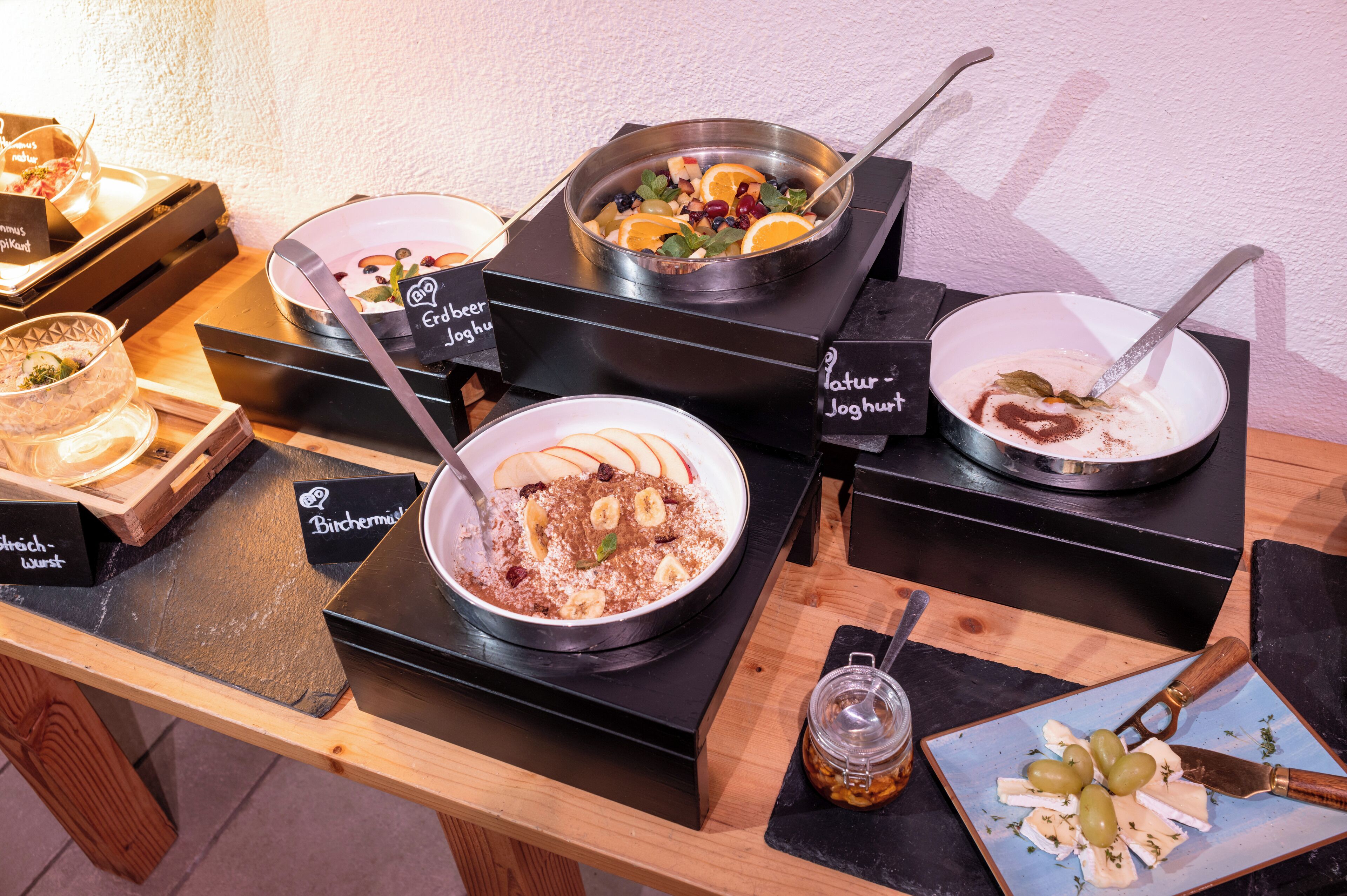 Una mesa de buffet con diferentes platos y un frasco de pepinillos.