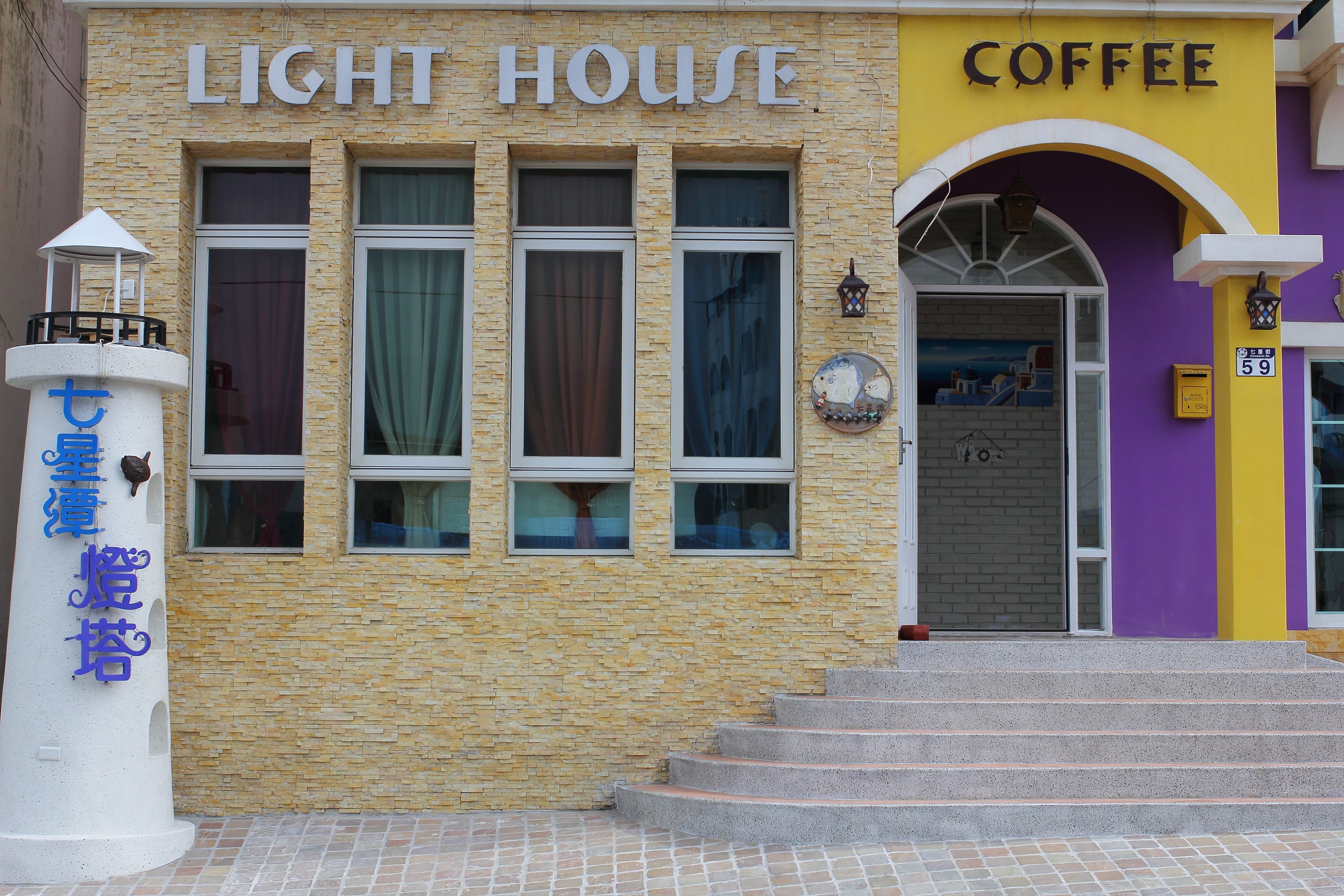 Een gebouw met een bord waarop 'LIGHT HOUSE COFFEE' staat.