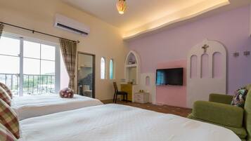 A hotel room with two beds, a TV, a small desk, a chair, and a balcony with a view.