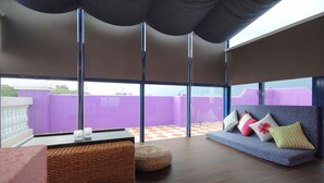 Et moderne interiør med en sofa, skottomanner og et bord.