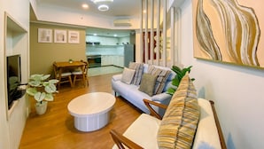 A modern living room with a sofa, coffee table, and dining area. - Cozy 2 Bedrooms Sudirman Tower Apartment by Travelio (Jakarta)