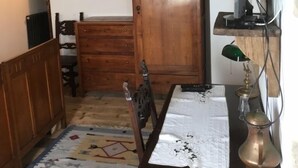 Una habitación acogedora con una mesa de comedor de madera, un tapete estampado, un aparador de madera y una puerta que da a otra habitación.