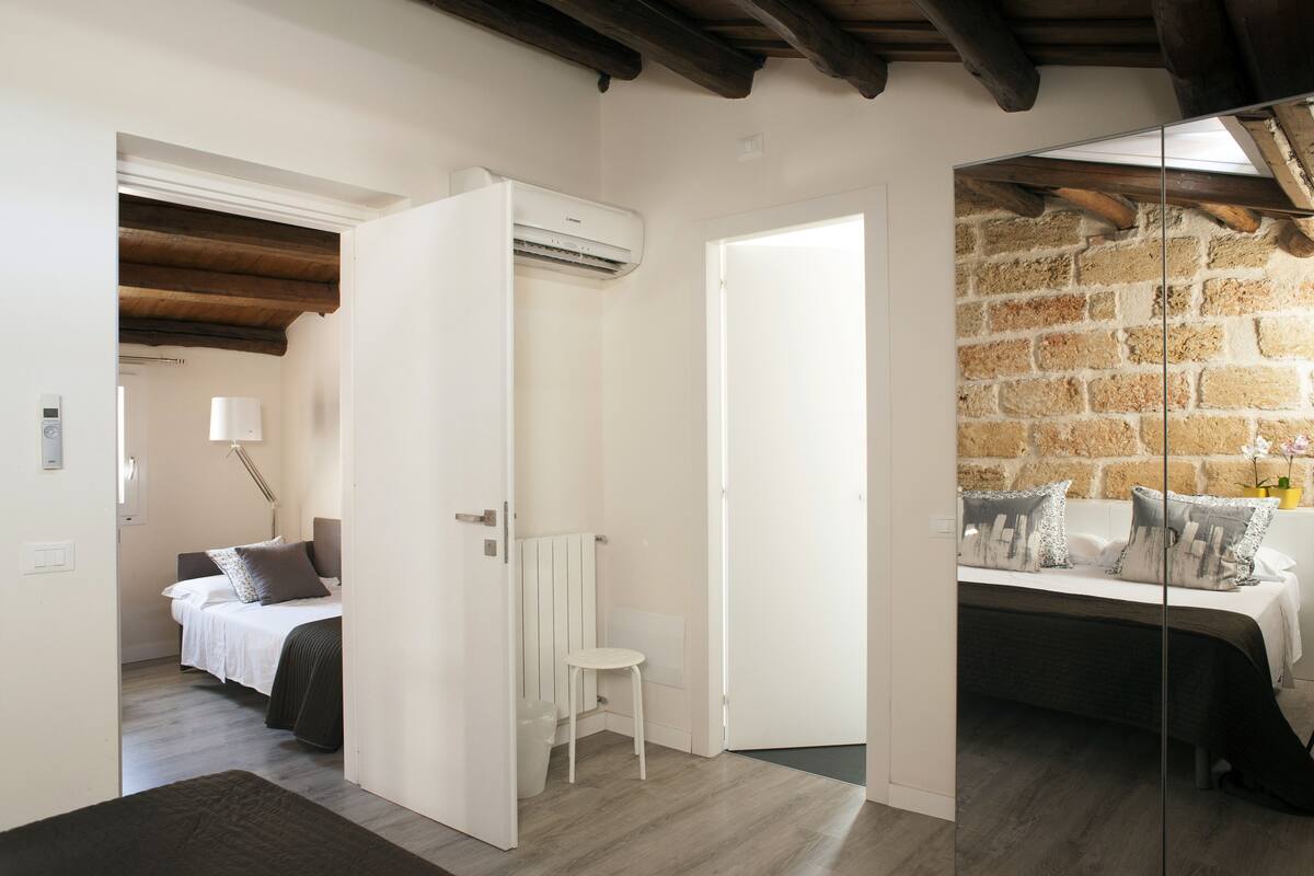 A bedroom with a bed, bedside table, and a white radiator.