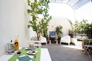 A breakfast setup with a coffee maker, orange juice, and a plate of food on a table. - B&B Cannoli (Palermo)