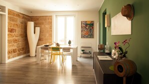 Un intérieur moderne comprenant un coin repas, une grande sculpture abstraite et un mur d’accent de couleur verte.