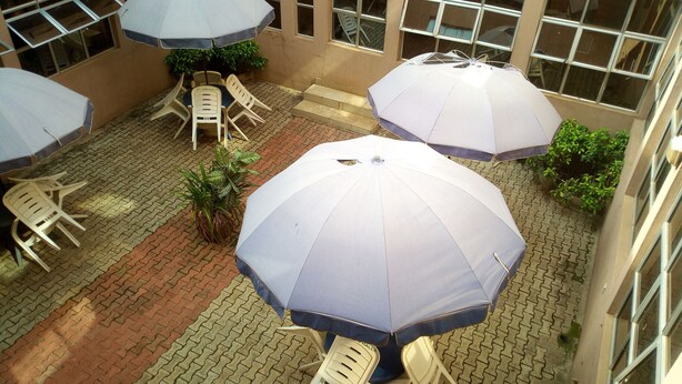 Un patio con mobiliario exterior y sombrillas.