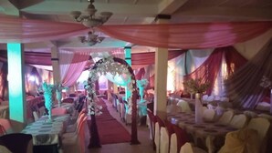 Un espacio interior para eventos, con mesas y sillas dispuestas.