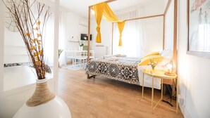 A modern bedroom with a four-poster bed, a bedside table with a lamp, and a desk with a chair. - Le Stanze Di Brando E Nico (Tricase)