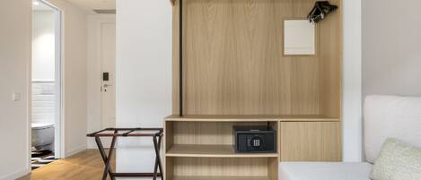 A modern room with a wooden cabinet, a black safe, and a white sofa.