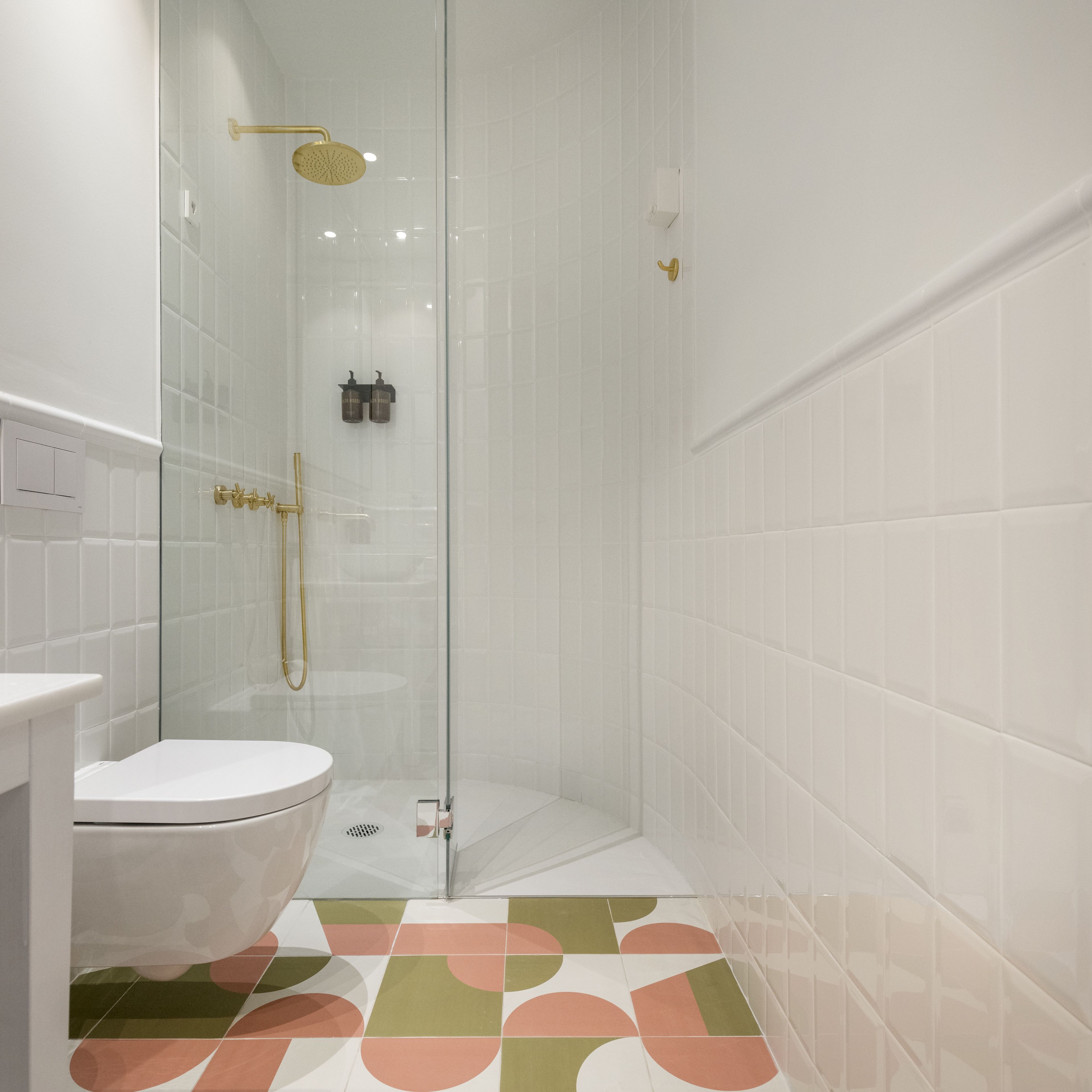A modern bathroom with a glass-enclosed shower, a toilet, and a sink.