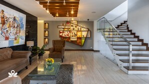 Ein modernes Wohnzimmer mit Sofa, Couchtisch und Wandgemälde.