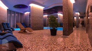 A spa area with a pool, lounge chairs, and a starry ceiling design. - White Tower Mamaia (Navodari)