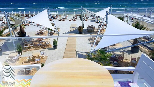 A beachside resort with outdoor seating areas and umbrellas, overlooking the ocean. - White Tower Mamaia (Navodari)