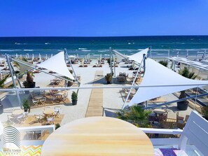 A beachside resort with outdoor seating areas and umbrellas, overlooking the ocean. - White Tower Mamaia (Navodari)