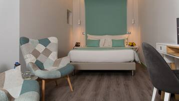 A modern bedroom with a bed, a chair, a desk, and a nightstand.