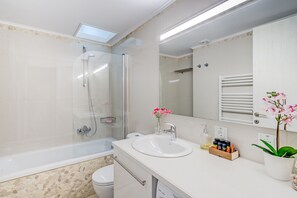 A modern bathroom with a glass-enclosed shower, a white sink, and a large mirror. - Grande Casa 1926 (Chania)