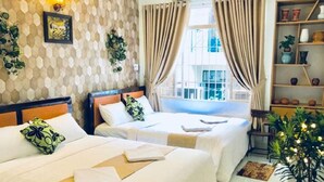 Habitación de hotel con dos camas, una ventana con cortinas, una pared con diseño tipo panal de abeja y una repisa con adornos.