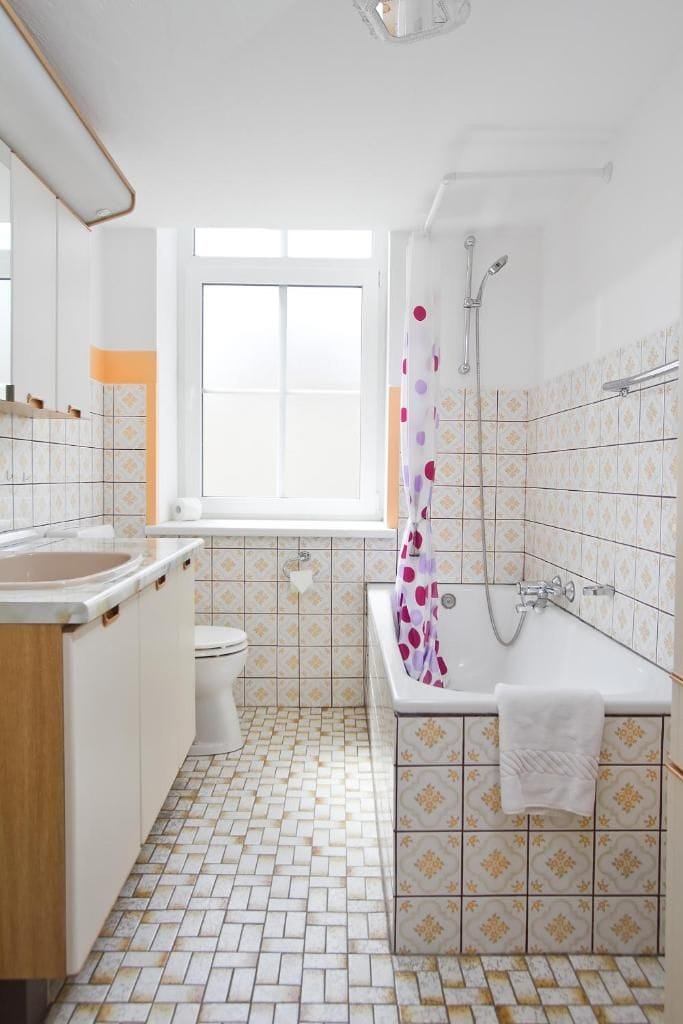 A bathroom with a toilet, sink, bathtub, and shower.