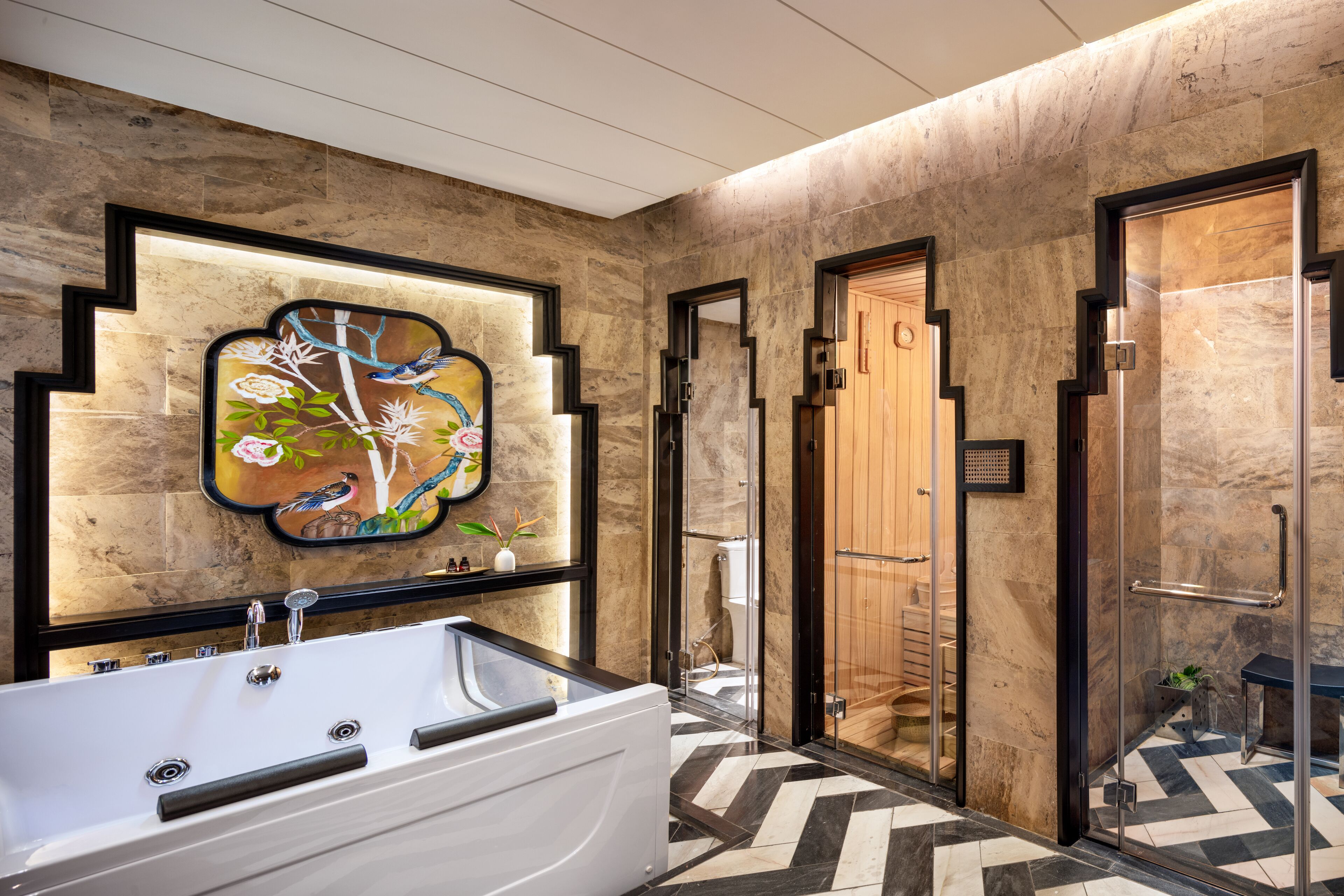 Un baño moderno con una bañera grande, una cabina de ducha de vidrio y un adorno en la pared.