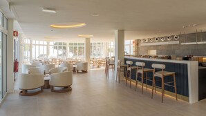 A modern restaurant with a bar area, seating arrangements, and a view of the outdoors. - Hapimag Resort Albufeira (Albufeira)