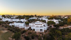 A cluster of white buildings with multiple balconies, surrounded by greenery and trees. - Hapimag Resort Albufeira (Albufeira)