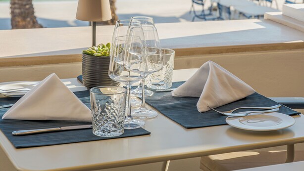 A dining table with a view of a pool and palm trees. - Hapimag Resort Albufeira (Albufeira)