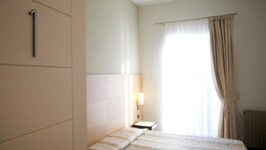 Une chambre d’hôtel avec un lit, une table de chevet, une lampe et une fenêtre avec des rideaux.