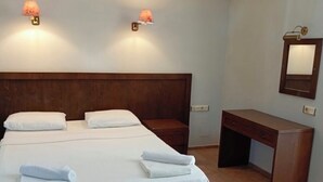 A hotel room with a large bed, two bedside tables, a desk, and two wall-mounted lamps. - Es Apartments (Marmaris)