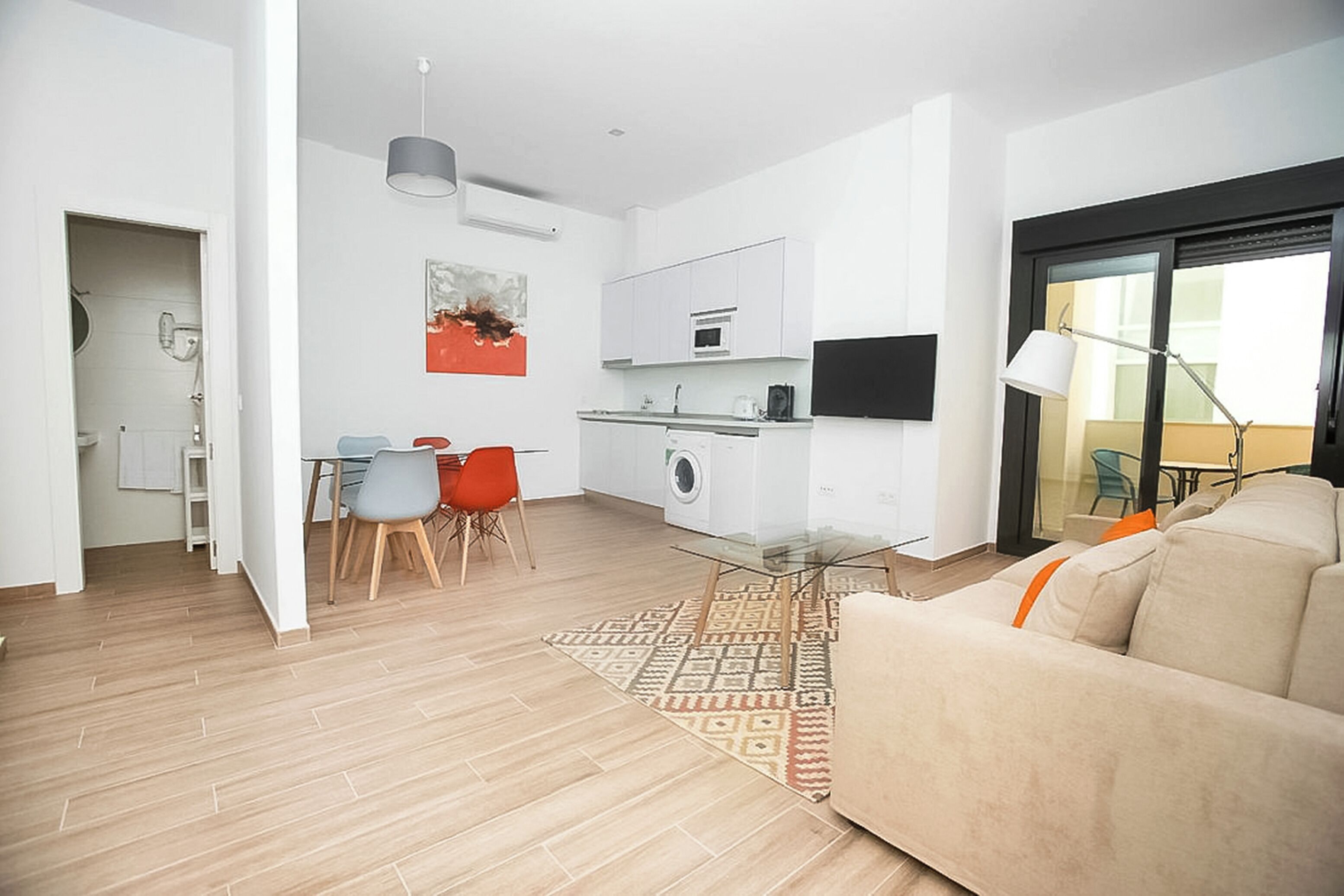 A modern apartment with a dining area, kitchen, and living room.