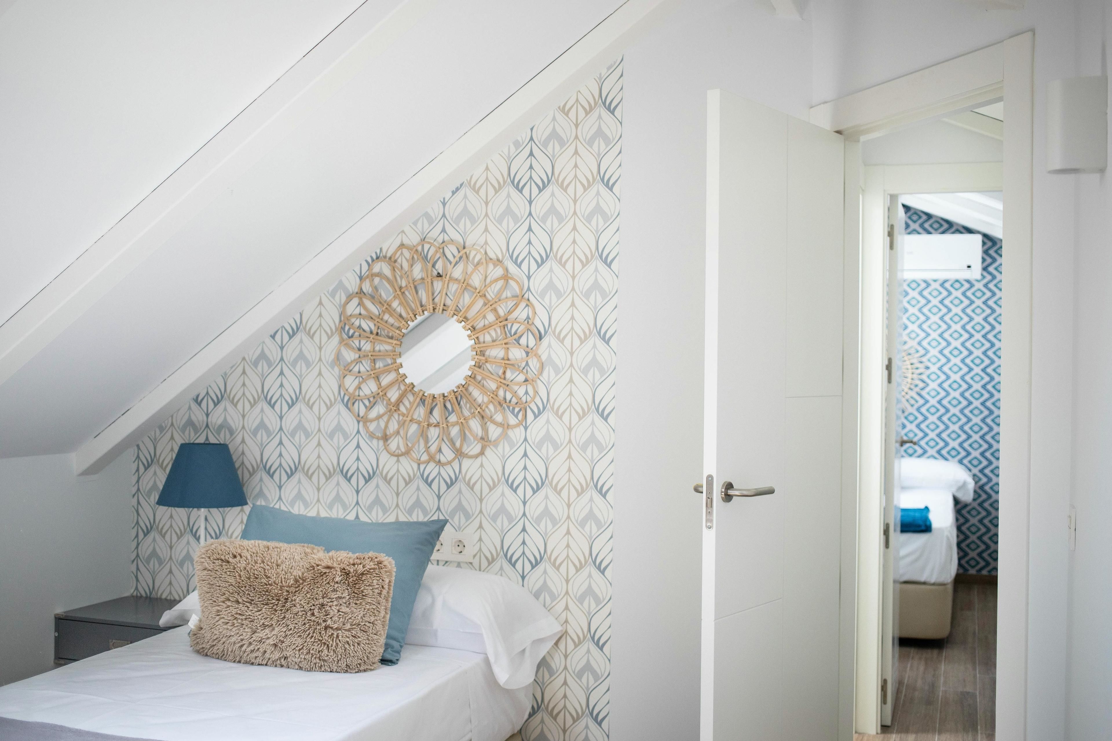 Ein Schlafzimmer mit einem Bett, Wanddeko und einem gemusterten Wandteppich.