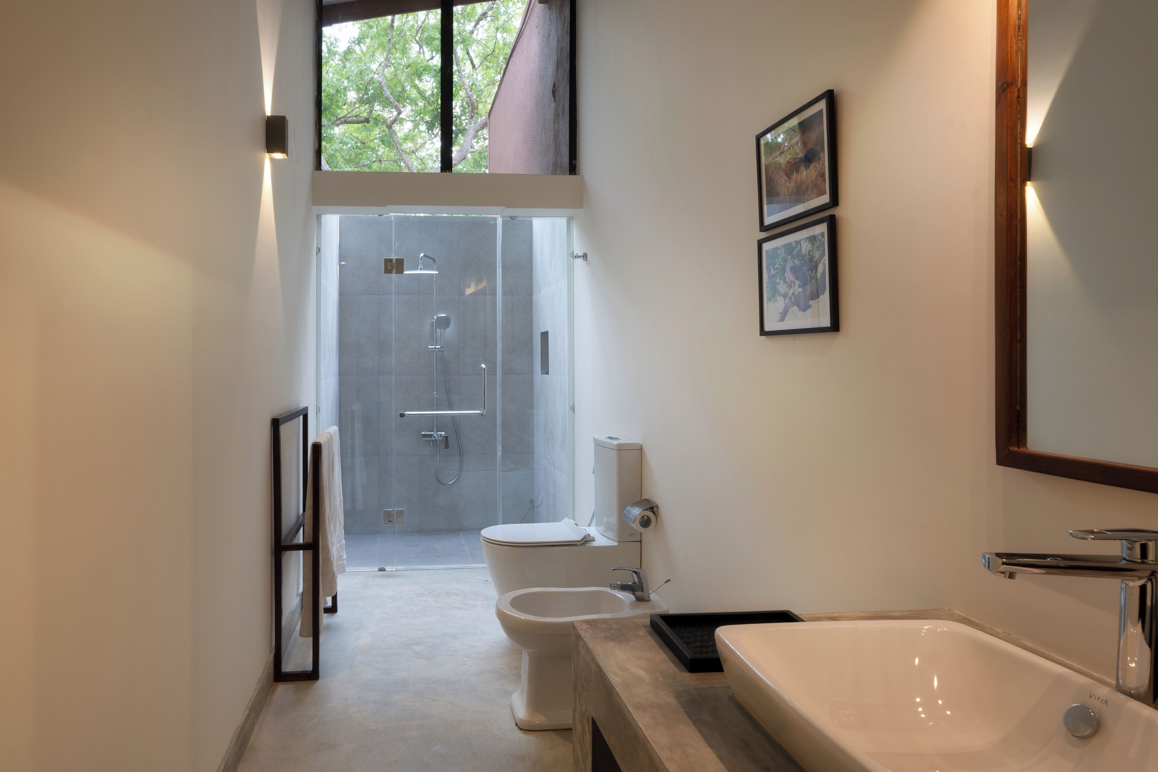 A modern bathroom with a bathtub, toilet, and shower.