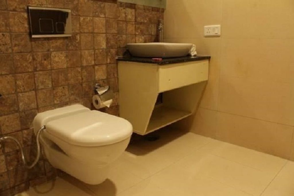 A bathroom with a toilet, a sink, and a towel rack.