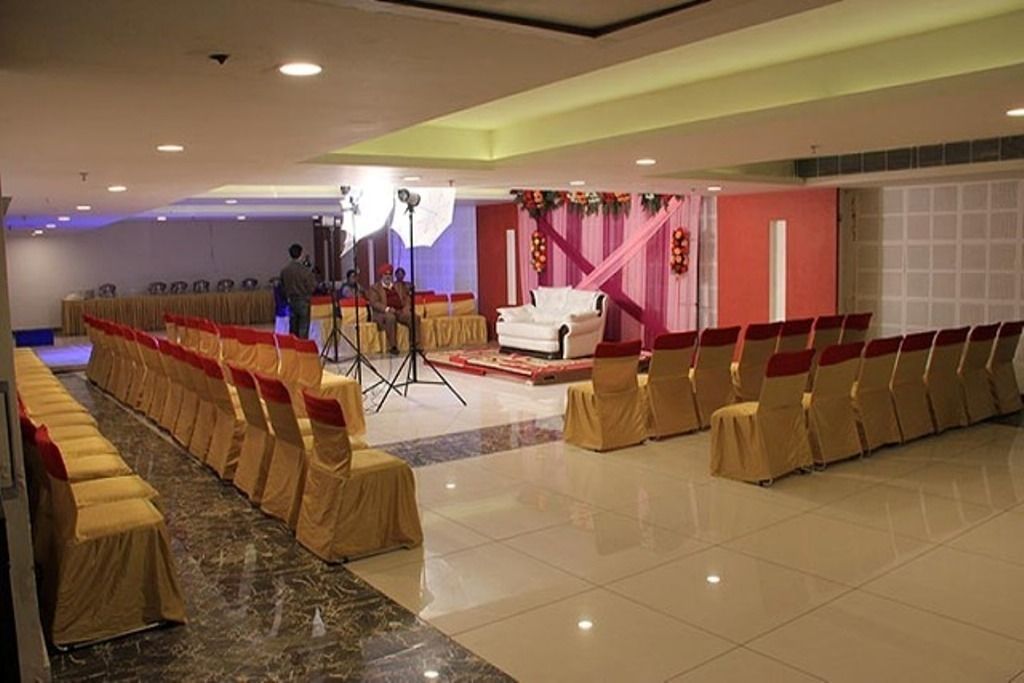 Uma sala de banquetes com fileiras de cadeiras e um palco.