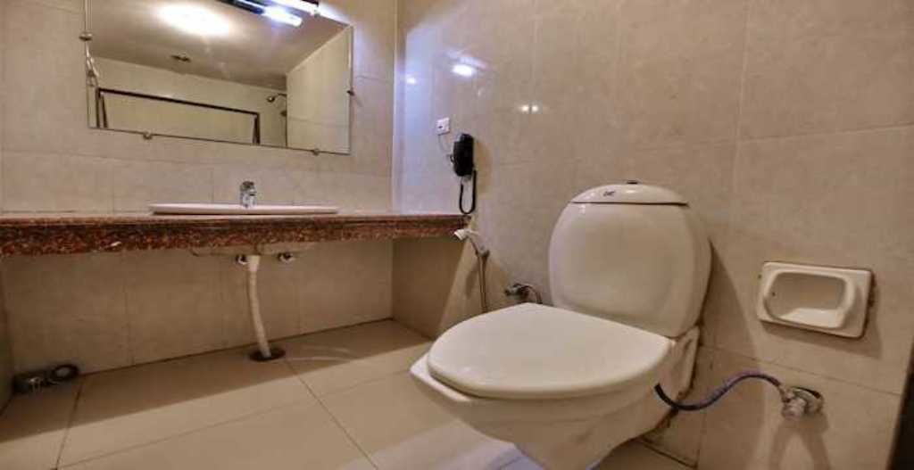 A small bathroom with a toilet, sink, and mirror.