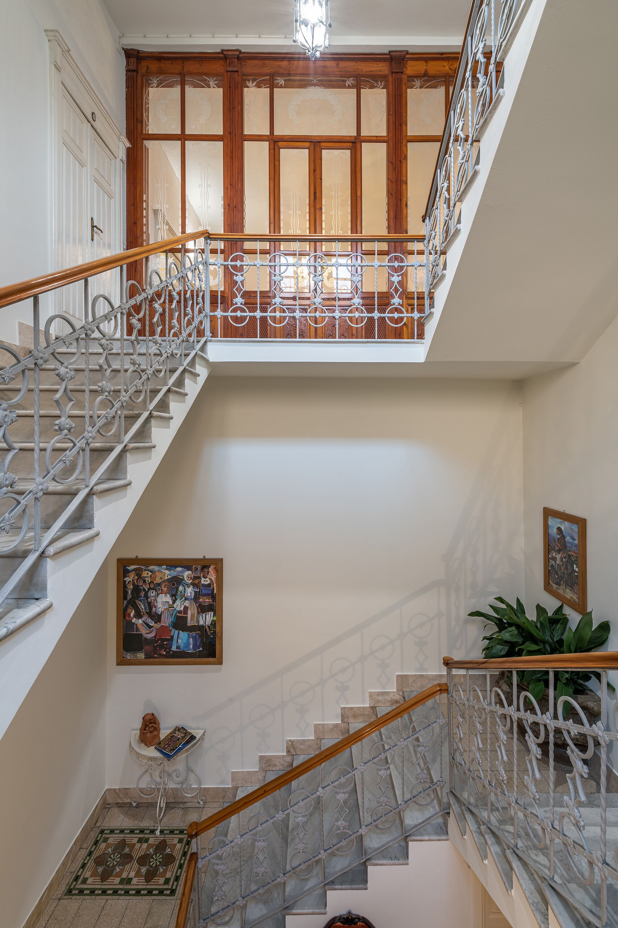 A multi-level staircase with ornate metal railings and wooden steps.